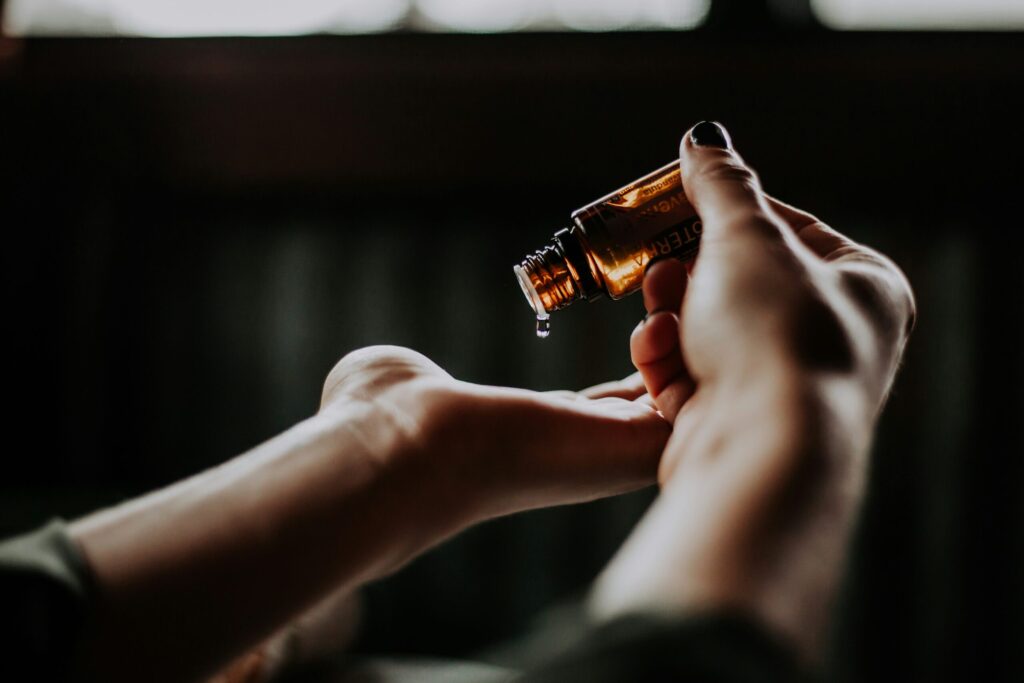 Lady pouring perfume oil in hands